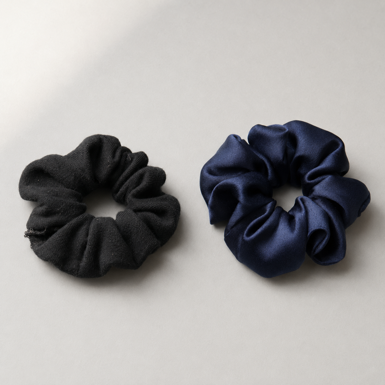 Comparatif entre un chouchou synthétique noir et un chouchou en soie bleu navy