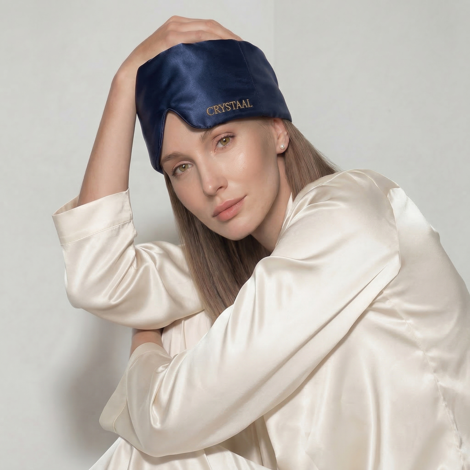 Femme portant un masque de nuit en soie 22 momme bleu Riviera CRYSTAAL, accessoire sommeil en soie pour bloquer la lumière et protéger la peau