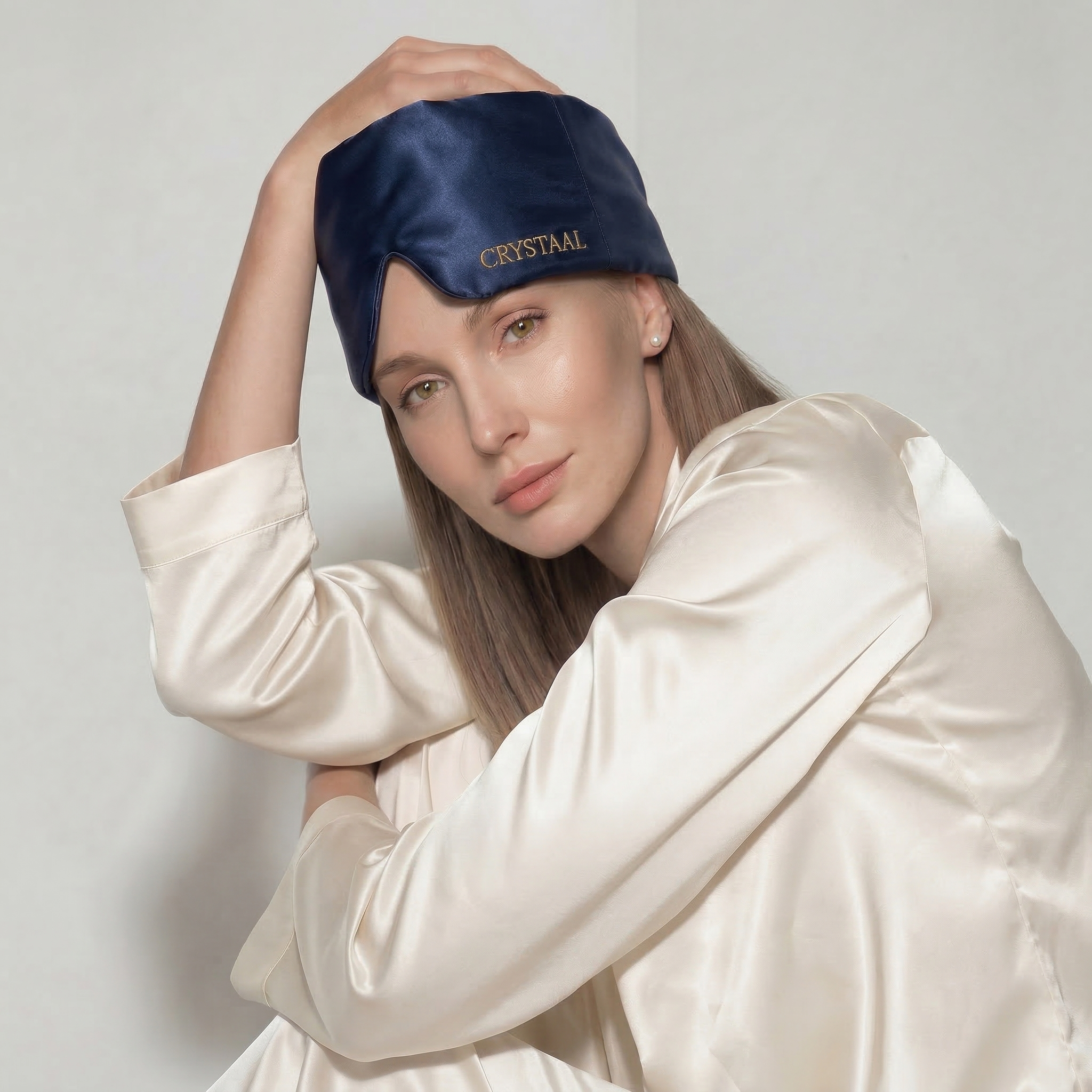 Femme portant un masque de nuit en soie 22 momme bleu Riviera CRYSTAAL, accessoire sommeil en soie pour bloquer la lumière et protéger la peau