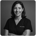 portrait noir et blanc d’une femme souriante en tenue professionnelle, bras croisés, style premium et rassurant