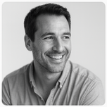 portrait noir et blanc d’un homme souriant en chemise claire, style lifestyle premium et rassurant